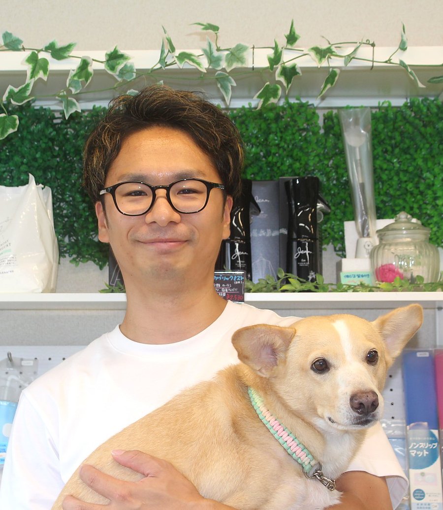 犬を抱く美容師の真保勇樹